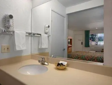 a bathroom with a sink and a mirror at Orange Show Inn in San Bernardino