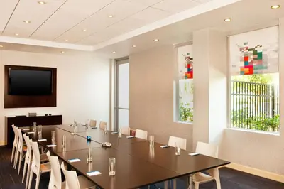 a conference room with a long table and chairs at Aloft Ontario-Rancho Cucamonga in Rancho Cucamonga