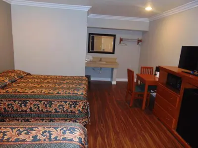 a hotel room with a bed and a desk at West Coast Inn Santa Ana in Santa Ana