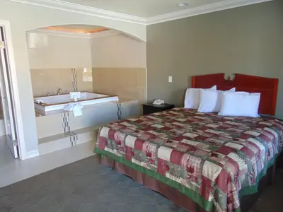 a hotel room with a bed and a sink at West Coast Inn Santa Ana in Santa Ana