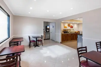 a dining room with tables and chairs and a kitchen at Quality Inn - Torrance Lomita in Lomita