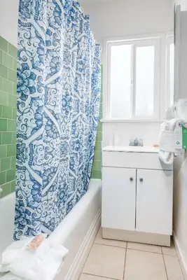 a bathroom with a blue and white shower curtain at Wilshire Motel in Los Angeles