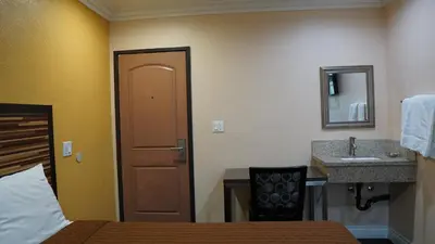 a hotel room with a bed and a sink at Holly Crest Hotel - Los Angeles, LAX Airport in Inglewood