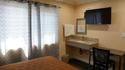 a hotel room with a bed and a sink at Holly Crest Hotel - Los Angeles, LAX Airport in Inglewood
