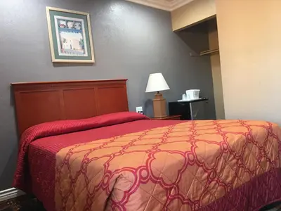 a bedroom with a bed with a red blanket at Budget Inn LAX-Lawndale in Lawndale
