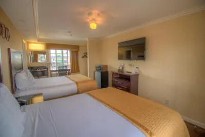 a hotel room with two beds and a television at Princess Inn in Westminster