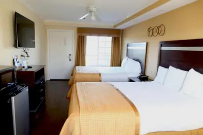 a hotel room with two beds and a flat screen tv at Princess Inn in Westminster