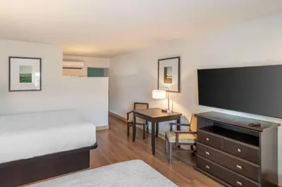 a hotel room with a bed and a desk with a television at Best Western At Ventura Pier in Ventura