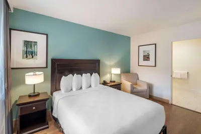 a hotel room with a large bed and a chair at Best Western At Ventura Pier in Ventura