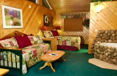 a room with a couch and a bed and a sink at Giant Oaks Lodge in Running Springs