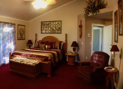 a bedroom with a bed and a chair at Giant Oaks Lodge in Running Springs
