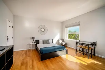 a bedroom with a bed and a desk and a window at AIR Venice on the Beach in Los Angeles