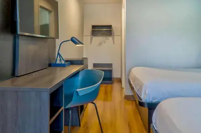 a room with a desk with a bed and a desk with a lamp at Motel 6-El Monte, CA - Los Angeles in El Monte