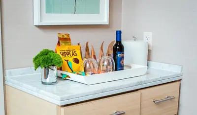 a counter top with a bottle of wine and glasses at Kimpton Hotel Wilshire by IHG in Los Angeles