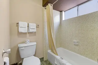 a bathroom with a toilet and a tub and a shower at Economy Inn Barstow in Barstow