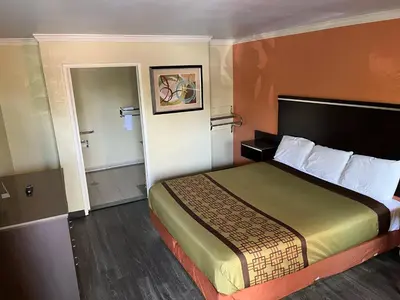 a hotel room with a bed and a bathroom at Rivera Inn & Suites Motel in Pico Rivera