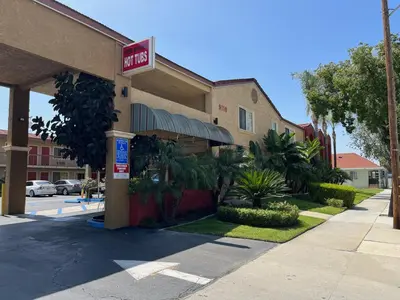 a hotel with a sign on the front of it at Rivera Inn & Suites Motel in Pico Rivera