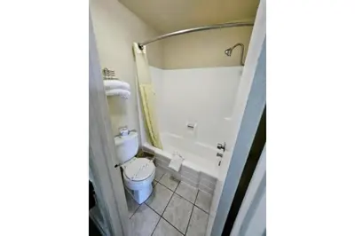 a bathroom with a toilet and a bath tub at Hotel Ridgecrest An Extended Stay Studio in Ridgecrest