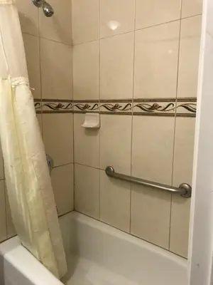a bathroom with a tub and a shower curtain at Flamingo Motel Oxnard in Oxnard