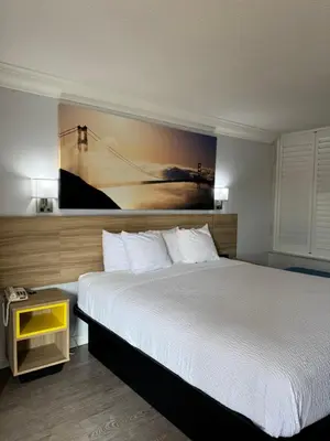 a bedroom with a bed and a painting on the wall at Days Inn by Wyndham Near City Of Hope in Duarte