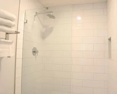 a white bathroom with a shower with a glass door at Days Inn by Wyndham Near City Of Hope in Duarte