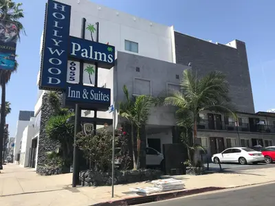 a sign for a hotel on the side of a street at Hollywood Palms Inns & Suites in Los Angeles