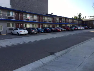 a row of cars parked in front of a building at Hollywood Palms Inns & Suites in Los Angeles