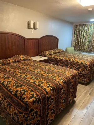 a hotel room with two beds in a room at Regency Inn in Norco