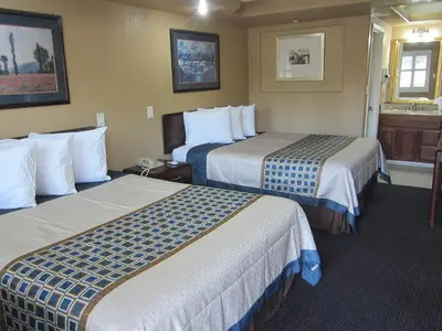 a hotel room with two beds and a sink at Little Boy Blue Motel in Anaheim