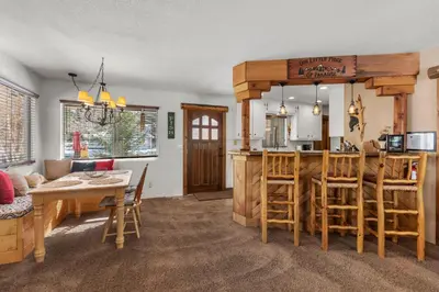 a kitchen and living room with a table and a bar at Piece of Paradise in Big Bear Lake