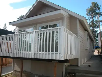 a house with a white deck on a porch at Big B's Den in Big Bear Lake