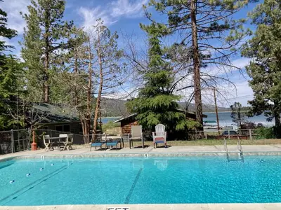 a swimming pool with chairs and a house at Lodge House-Family Cabin with Pool Table by Big Bear Vacations in Big Bear Lake