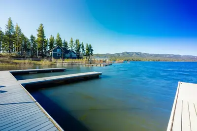 a view of a lake with a house and a dock at Big Pines Couple Lakeview Studio Cabin by Big Bear Vacations in Big Bear Lake