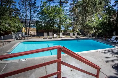a swimming pool with a wooden fence around it at Lakeview Family Cabin by Big Bear Vacations in Big Bear Lake