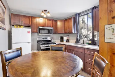 a kitchen with a wooden table and a table and chairs at Lonepine Lakeside Resort Retreat by Big Bear Vacations in Big Bear Lake