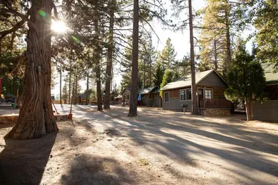a park with a house and trees and a bench at Sunrise Lakefront Family Cabin by Big Bear Vacations in Big Bear Lake