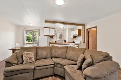 a living room with a brown couch and a kitchen at Twin Pines Family Cabin by Big Bear Vacations in Big Bear Lake