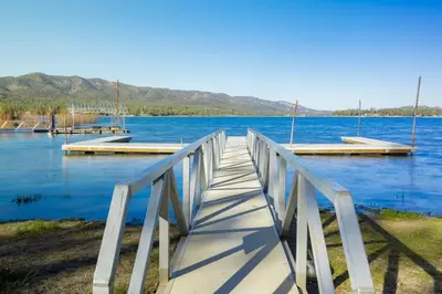a wooden bridge over a large body of water at Twin Pines Family Cabin by Big Bear Vacations in Big Bear Lake