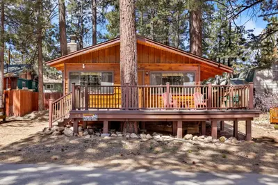 a cabin in a tree with a large deck at Casa Catalina-667 by Big Bear Vacations in Big Bear Lake