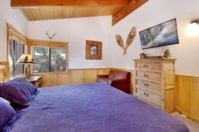 a bedroom with a bed and a chair and a dresser at Casa Catalina-667 by Big Bear Vacations in Big Bear Lake