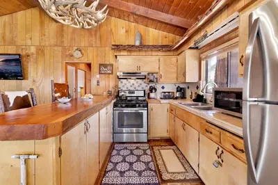 a kitchen with wooden cabinets and stainless steel appliances at Casa Catalina-667 by Big Bear Vacations in Big Bear Lake