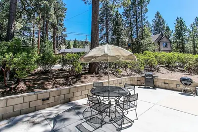 a table and chairs with an umbrella on a patio at Switzerland Ski Chalet-845 by Big Bear Vacations in Big Bear Lake