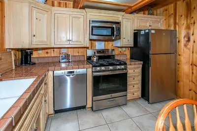a kitchen with stainless steel appliances and wooden cabinets at Switzerland Ski Chalet-845 by Big Bear Vacations in Big Bear Lake