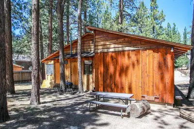 a wooden cabin with a picnic table in front of it at Avalon Hide Out-1336 by Big Bear Vacations in Big Bear Lake