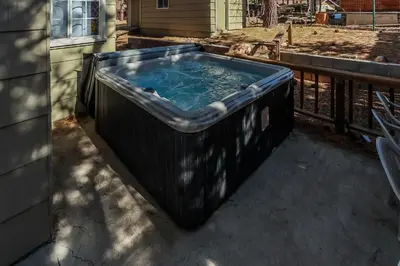 a large bath tub sitting on a patio at Life of Riley-1608 by Big Bear Vacations in Big Bear Lake