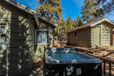 a house with a tub next to a building at Life of Riley-1608 by Big Bear Vacations in Big Bear Lake