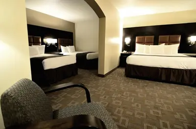 a hotel room with two beds and a chair at Days Inn by Wyndham Downey in Downey