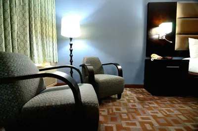 a hotel room with two chairs and a bed at Days Inn by Wyndham Downey in Downey