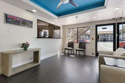 a living room with a couch and chairs and a ceiling at Days Inn by Wyndham Downey in Downey