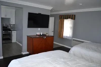 a bedroom with a bed and a flat screen tv at Rex Motel in Ventura